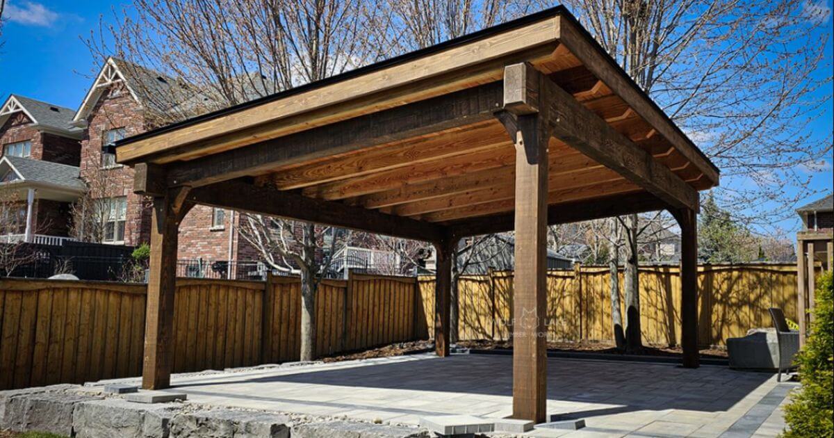 Timber pavilion with flat roof in backyard.